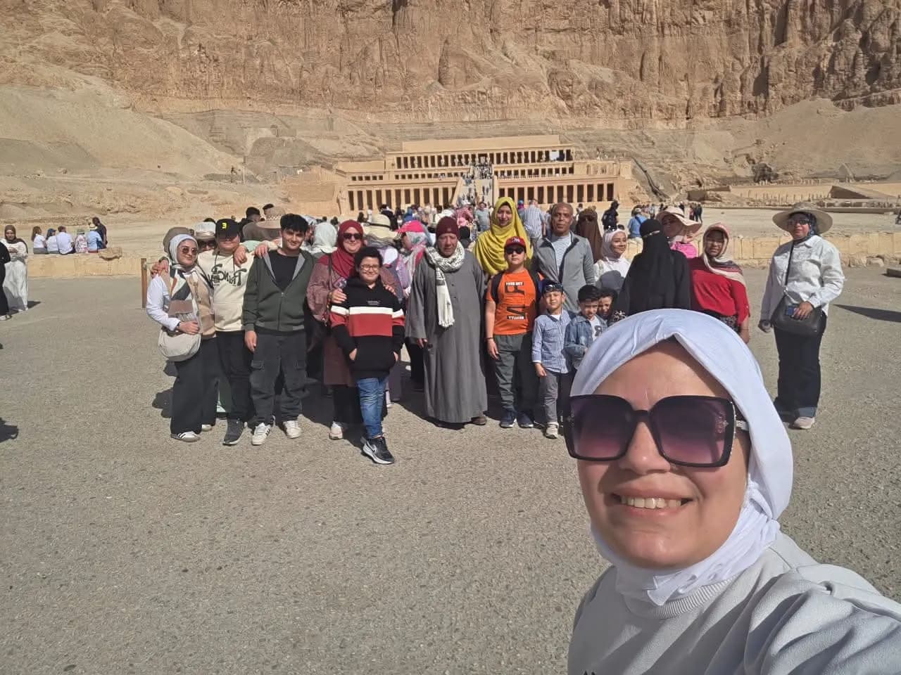 A tour group taking a selfie in front of the Temple of Hatshepsut, Luxor