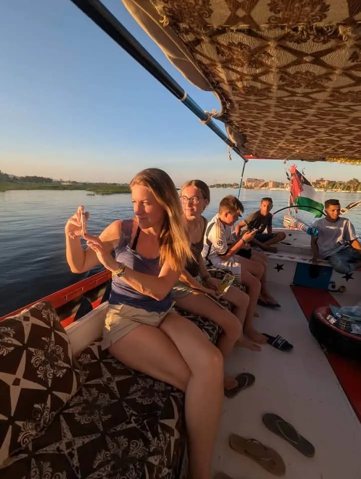 Travelers relaxing on a Nile felucca at sunset