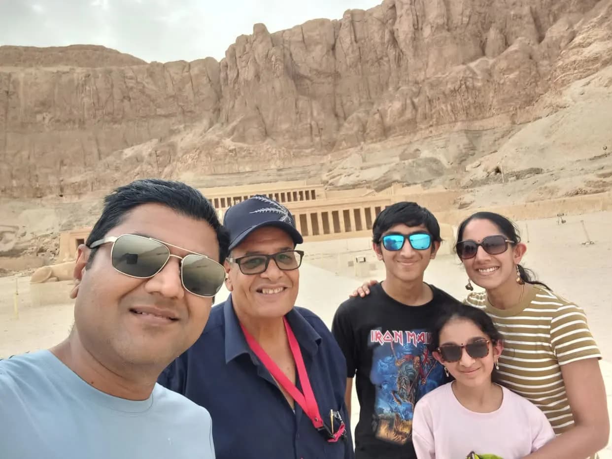 A family taking a selfie in front of the Temple of Hatshepsut, Luxor
