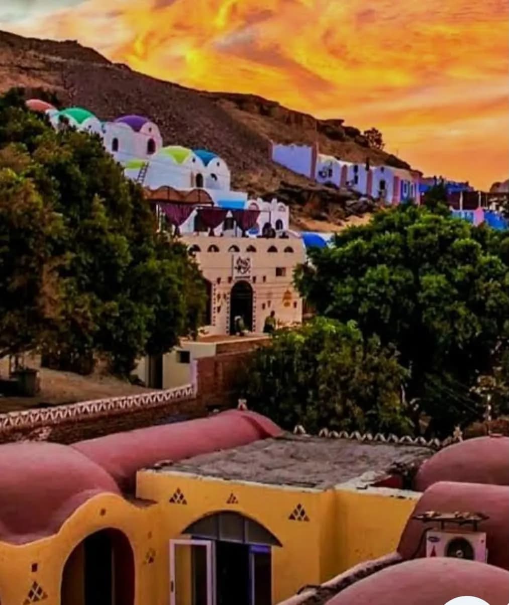 Colorful Nubian village houses on a hillside at sunset near Aswan