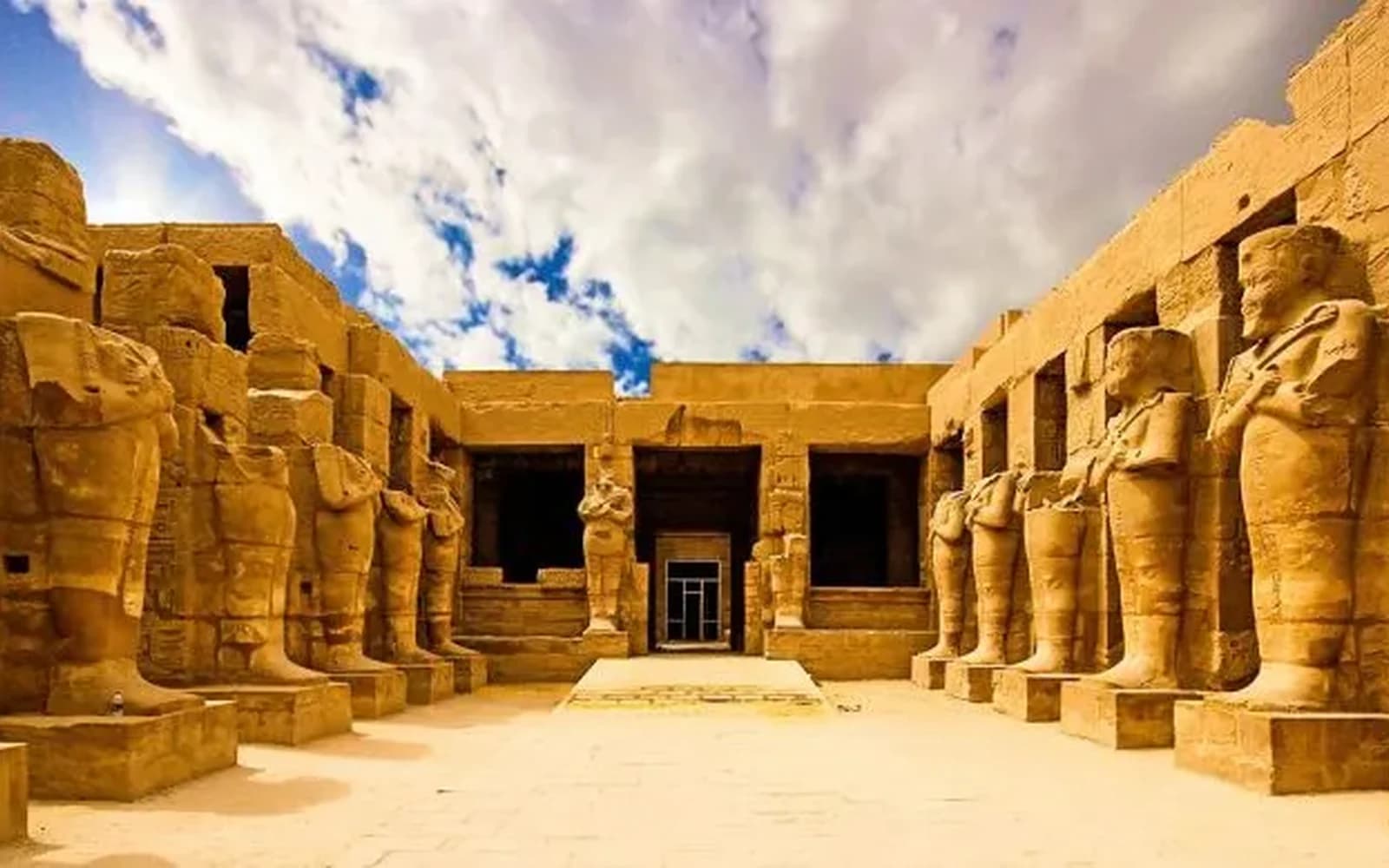 Karnak's great columns lit amber against a midnight-blue sky during the evening show.